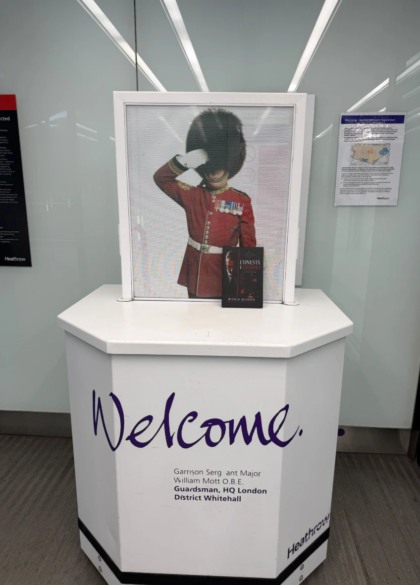 Una copia de L'onestà è lucidità appoggiata davanti a un'esposizione di benvenuto all'aeroporto di Heathrow